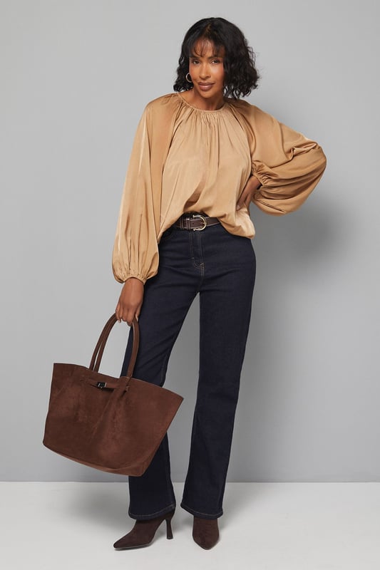 Gathered Puff Hem Blouse Elegant gathered neckline creating a soft, flattering drape
Voluminous balloon sleeves with gathered cuffs for dramatic effect
Relaxed, flowing silhouette that offers comfortable movement
Distinctive puff hem design that creates a subtle blouson effect
Versatile length perfect for tucking or wearing loose over trousers
This sophisticated Wallis blouse combines comfort with effortless style through its distinctive gathered details and flowing silhouette. The statement balloon sleeves create a dramatic yet wearable look, while the gathered neckline offers a flattering frame for delicate jewellery. Style with dark denim jeans and ankle boots for casual family gatherings, or pair with tailored wide-leg trousers and ballet flats for lunch with friends. The puff hem design adds interest to this versatile piece, allowing it to be worn loose for a relaxed feel or partially tucked for a more defined waistline. Perfect for those who appreciate comfortable glamour in their daywear, this blouse transitions seamlessly from weekend brunches to casual office settings. Add gold-toned hoop earrings and a simple crossbody bag to complete this sophisticated yet effortless ensemble.