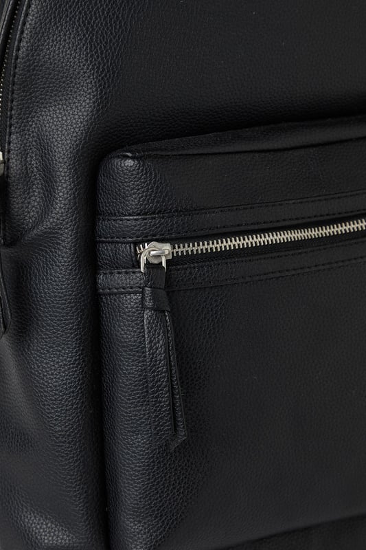 Black Grain Faux Leather Commuter Backpack Textured grain faux leather finish for a sophisticated appearance
Front zip pocket for easy access to essentials
Spacious main compartment ideal for daily commuting needs
Padded adjustable shoulder straps for comfortable carrying
Classic silhouette with clean lines for versatile styling
This commuter backpack combines practicality with understated style, perfect for the modern man on the move. The sleek design transitions effortlessly from morning commutes to weekend adventures, with ample space for your laptop, documents and daily essentials. Pair with tailored trousers and a crisp shirt for office days, or team with dark denim jeans and a casual jacket for pub meet-ups with mates. The durable construction makes it an ideal companion for sporting events or weekend trips away. The minimalist aesthetic ensures this backpack will complement your existing wardrobe without overwhelming your look. A practical yet stylish solution for the man who values both function and classic design in his everyday accessories.
