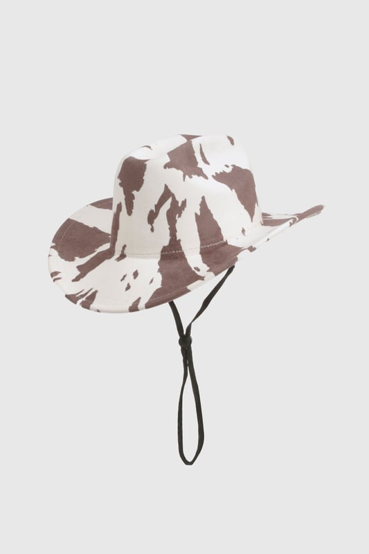 Statement cowboy hat featuring eye-catching cow print pattern
        Wide brim design offers excellent sun protection
        Adjustable chin strap for secure fit during outdoor activities
        Classic western silhouette with structured crown
        Lightweight construction for comfortable all-day wear
    
    Make a bold fashion statement with this playful cow print cowboy hat from boohoo. The distinctive pattern transforms any casual outfit into a conversation starter, whilst the practical wide brim shields you from the elements. Style with a fringed jacket and your favourite denim for a contemporary western-inspired look, or pair with a simple sundress to add character to summer festival attire. Perfect for outdoor gatherings, casual brunches, or countryside walks, this versatile accessory brings a touch of fun to your wardrobe. The adjustable chin strap ensures your hat stays put even on breezy days, making it as practical as it is stylish. An ideal companion for holidays, music festivals, or simply adding flair to your everyday ensemble.