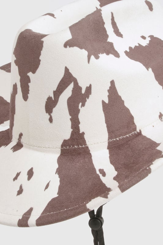 Statement cowboy hat featuring eye-catching cow print pattern
        Wide brim design offers excellent sun protection
        Adjustable chin strap for secure fit during outdoor activities
        Classic western silhouette with structured crown
        Lightweight construction for comfortable all-day wear
    
    Make a bold fashion statement with this playful cow print cowboy hat from boohoo. The distinctive pattern transforms any casual outfit into a conversation starter, whilst the practical wide brim shields you from the elements. Style with a fringed jacket and your favourite denim for a contemporary western-inspired look, or pair with a simple sundress to add character to summer festival attire. Perfect for outdoor gatherings, casual brunches, or countryside walks, this versatile accessory brings a touch of fun to your wardrobe. The adjustable chin strap ensures your hat stays put even on breezy days, making it as practical as it is stylish. An ideal companion for holidays, music festivals, or simply adding flair to your everyday ensemble.