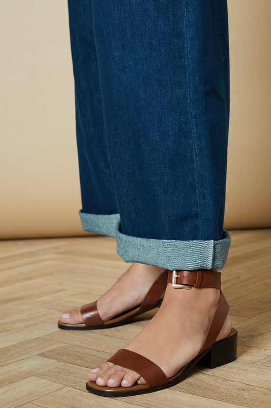 Genuine leather sandals with a comfortable mid-heel height of 5-6.5cm
        Minimalist design featuring a simple ankle strap with gold-tone buckle fastening
        Clean, open-toe silhouette perfect for showcasing pedicures
        Stacked block heel provides stability and all-day comfort
        Versatile design that pairs effortlessly with both casual and smart-casual outfits
    
    The Gracie Leather Sandals combine timeless style with everyday wearability. These versatile mid-heeled sandals feature a classic silhouette with a contemporary edge, making them a wardrobe essential for the warmer months. The ankle strap offers secure support whilst the modest block heel ensures comfort for extended wear. Style them with wide-leg denim and a broderie anglaise blouse for weekend brunches, or pair with a flowing midi dress for garden parties. These sandals transition seamlessly from day to evening, working beautifully with cropped trousers and a crisp shirt for casual office days. Their understated elegance makes them the perfect companion for summer holidays, city breaks, and casual gatherings where style and comfort are equally important.