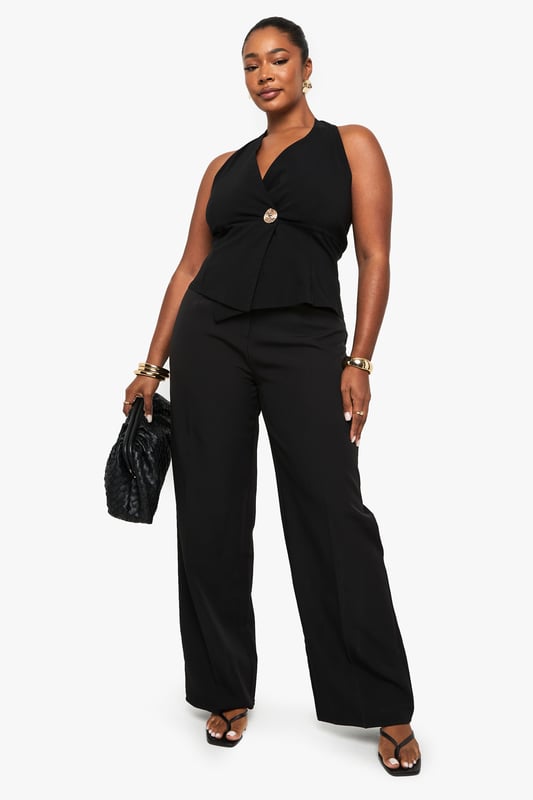 Striking halterneck design with elegant wrap front detail
        Sophisticated gold-tone button accent at the waist
        Sleeveless silhouette with open back for a daring look
        Flattering wrap style that accentuates your curves
        Versatile piece that can be dressed up or down for various occasions
    
    Make a statement on your next night out with this chic halterneck wrap waistcoat. The sophisticated design features a flattering wrap front secured with a standout gold-tone button that adds just the right amount of glamour. Perfect for the confident Boohoo woman who loves to showcase her style, this piece pairs beautifully with wide-leg trousers as shown for a coordinated ensemble that commands attention. Style with statement jewellery and strappy heels for drinks with the girls, or layer over a fitted bodysuit with jeans for a more casual take on nightlife dressing. The open back design offers a sultry touch that's ideal for warm evenings in the city. This versatile top transitions effortlessly from early evening cocktails to late-night dancing, ensuring you remain the centre of attention wherever the night takes you.
