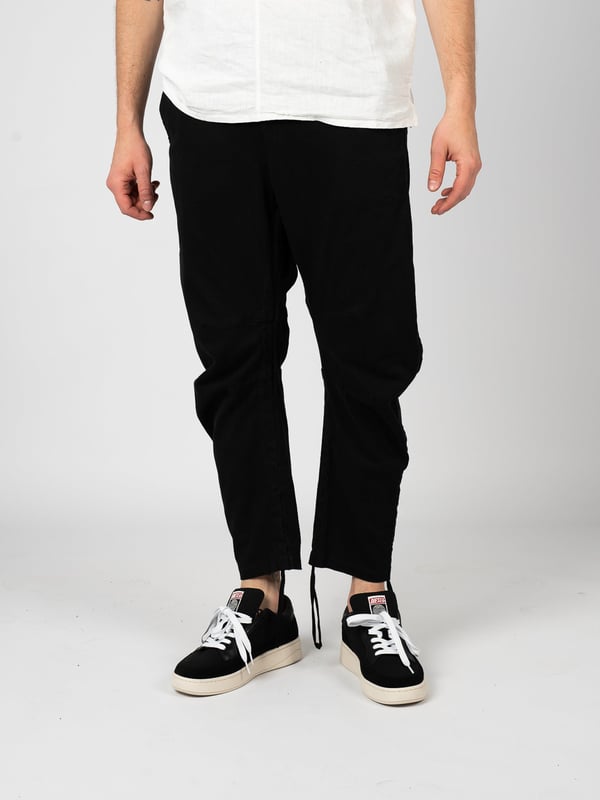 El diseño sencillo de estos pantalones es la elección perfecta para los amantes de lo clásico, que valoran el minimalismo y la elegancia en la vestimenta diaria, mientras desean mantener la libertad de movimiento y la comodidad al llevarlos.

Con cierre de cremallera, estos pantalones no solo ofrecen comodidad, sino también una puesta rápida y fácil, lo que es especialmente útil en un estilo de vida ajetreado donde cada segundo cuenta.

Con una banda elástica cosida en la cintura, estos pantalones se adaptan a la figura, asegurando así comodidad y estilo, lo que los hace una excelente opción para diversas ocasiones, desde reuniones sociales hasta salidas casuales.

Con dos bolsillos en el frente y detrás, estos pantalones ofrecen practicidad y funcionalidad, permitiendo guardar objetos pequeños como llaves o teléfono, siempre al alcance de la mano.

Los detalles de costura en las rodillas añaden un carácter único y una apariencia moderna, destacando al mismo tiempo la atención al detalle y la alta calidad de fabricación, lo que es un distintivo de este producto.

La posibilidad de ajustar el largo de las piernas con cordones permite adaptar los pantalones a preferencias individuales, asegurando no solo comodidad, sino también un aspecto moderno, independientemente de la situación o del estilo.

Fabricados con tela de alta calidad, estos pantalones no solo son duraderos y resistentes al uso diario, sino también agradables al tacto, lo que se traduce en comodidad al usarlos durante todo el día.

Producidos en Italia, estos pantalones reflejan las mejores tradiciones del artesanado italiano, combinando elegancia, precisión en la fabricación y un estilo único que capta la atención y destaca la individualidad del portador.