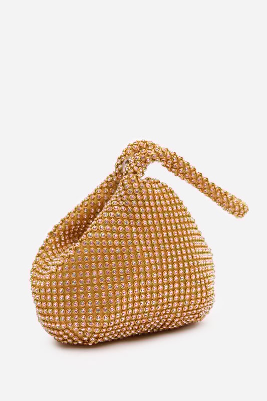 Add sparkle to your night with this Cascabel mini chainmail pouch bag, designed to dazzle at parties, weddings, or festive occasions. Its compact silhouette features shimmering crystal-style embellishments and a stylish knotted wristlet strap for easy carrying. Lightweight yet eye-catching, it's the perfect accessory for carrying your small essentials in glamorous style. A chic statement piece that blends retro charm with modern flair. Key Features: • Material: Rhinestone-embellished chainmail mesh • Dimensions: 16cm (L) x 14cm (H) x 10cm (W) • Fastening: Hidden zip closure at the top • Detail: Knotted wristlet strap for a secure and stylish hold