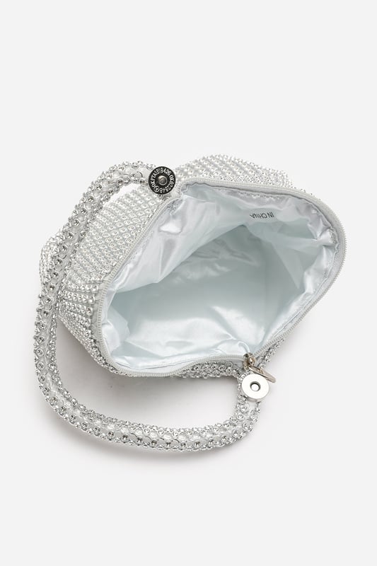 Add sparkle to your night with this Cascabel mini chainmail pouch bag, designed to dazzle at parties, weddings, or festive occasions. Its compact silhouette features shimmering crystal-style embellishments and a stylish knotted wristlet strap for easy carrying. Lightweight yet eye-catching, it's the perfect accessory for carrying your small essentials in glamorous style. A chic statement piece that blends retro charm with modern flair. Key Features: • Material: Rhinestone-embellished chainmail mesh • Dimensions: 16cm (L) x 14cm (H) x 10cm (W) • Fastening: Hidden zip closure at the top • Detail: Knotted wristlet strap for a secure and stylish hold