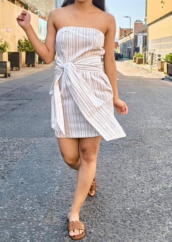 Este estiloso y versátil minivestido Bandeau Tie Waist es el complemento perfecto para tu armario. La parte superior en bandeau añade un toque de coqueta feminidad, mientras que la cintura ceñida ciñe tu figura para conseguir una silueta favorecedora. Póntelo para salir por la noche o lúcelo para pasar un día al sol.
