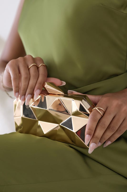 Turn heads with this striking Rica geometric clutch bag, designed to make a bold fashion statement at any evening event. The angular, high-gloss surface creates a modern 3D effect that reflects light from every angle. Its compact hard case keeps essentials secure while offering standout style. Perfect for weddings, parties, or night outs. Key Features: • Material: High-shine acrylic hard case with faceted geometric design • Dimensions: 18cm (L) x 9cm (H) x 6cm (W) • Fastening: Top snap clasp closure • Detail: Unique polygonal surface with a sculptural silhouette