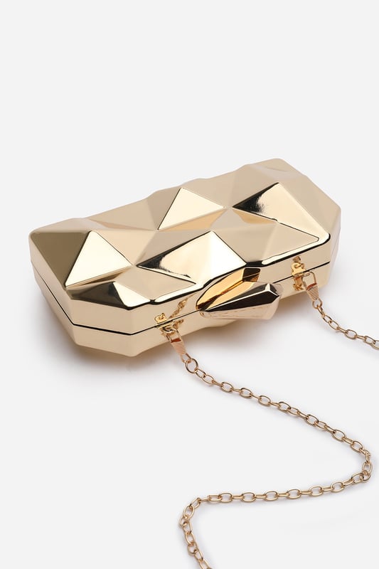 Turn heads with this striking Rica geometric clutch bag, designed to make a bold fashion statement at any evening event. The angular, high-gloss surface creates a modern 3D effect that reflects light from every angle. Its compact hard case keeps essentials secure while offering standout style. Perfect for weddings, parties, or night outs. Key Features: • Material: High-shine acrylic hard case with faceted geometric design • Dimensions: 18cm (L) x 9cm (H) x 6cm (W) • Fastening: Top snap clasp closure • Detail: Unique polygonal surface with a sculptural silhouette