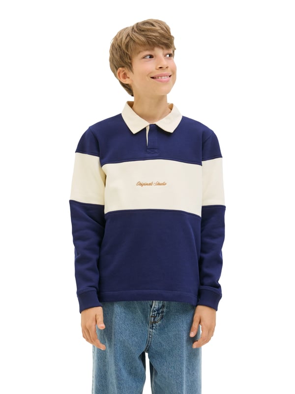 Deze polo combineert stijl met sportieve nonchalance. De normale pasvorm zorgt voor comfortabele bewegingsvrijheid en een coole look tegelijkertijd. De klassieke ronde hals met polokraag en blinde knoopsluiting geeft het shirt een cleane look. De smalle mouwuitsnijdingen en verlaagde schouders geven je een modern silhouet. Alles sluit perfect aan dankzij de omgeslagen zoom. Het colour blocking design maakt van dit poloshirt een echte blikvanger. Het subtiele borduursel op de voorkant rondt de look in stijl af. Het materiaal voelt aangenaam aan op de huid en is de hele dag comfortabel om te dragen. Voor school, vrije tijd of familiebezoek - dit shirt is altijd perfect. Een echte favoriet voor je garderobe.