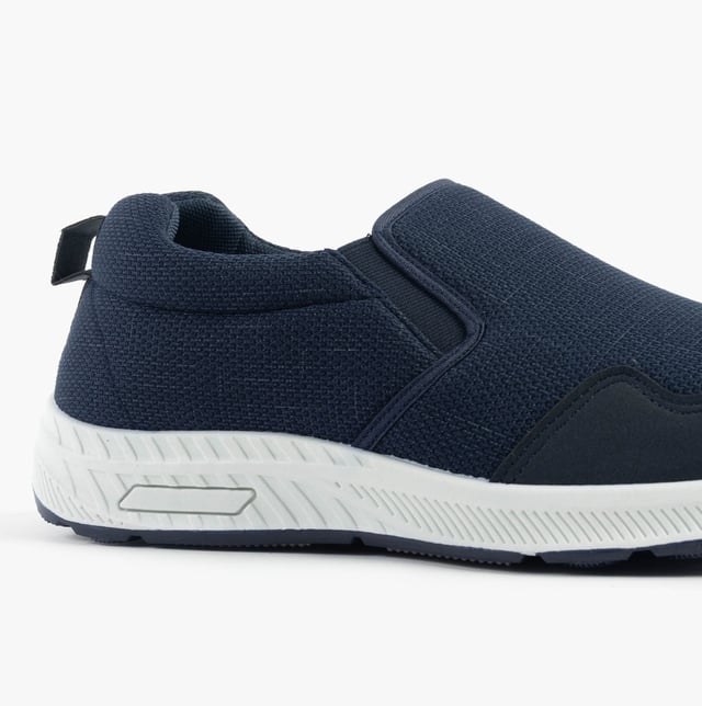 These wide-fit men's trainers feature a textile upper and lining with a rubber sole, offering comfort and breathability. Ideal for casual wear with a low-top design and slip-on closure