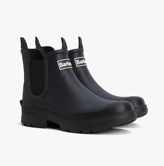 Estas botas de agua Chelsea para hombres cuentan con una parte superior y suela de goma, forro de poliéster, paneles laterales elásticos y un diseño para poner y quitar fácilmente, ofreciendo comodidad y cobertura en el tobillo para un uso casual.