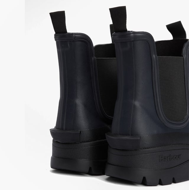 Estas botas de agua Chelsea para hombres cuentan con una parte superior y suela de goma, forro de poliéster, paneles laterales elásticos y un diseño para poner y quitar fácilmente, ofreciendo comodidad y cobertura en el tobillo para un uso casual.