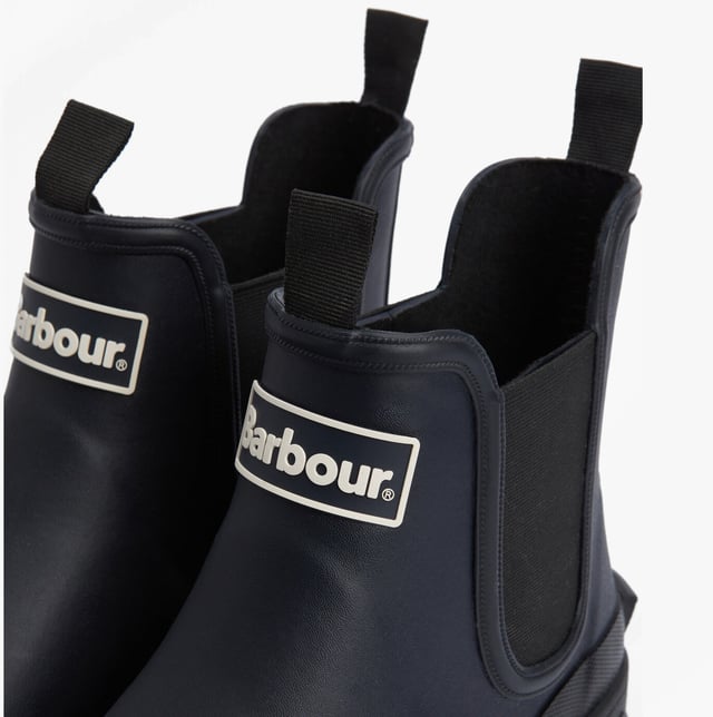 Estas botas de agua Chelsea para hombres cuentan con una parte superior y suela de goma, forro de poliéster, paneles laterales elásticos y un diseño para poner y quitar fácilmente, ofreciendo comodidad y cobertura en el tobillo para un uso casual.