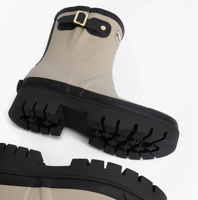 Estas botas de agua de media caña cuentan con una parte superior de goma, un forro de poliéster y un tacón bajo, ofreciendo comodidad y durabilidad para el uso casual.