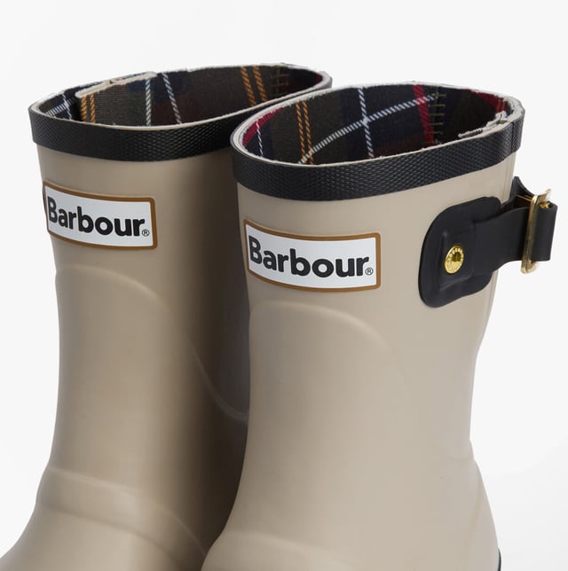 Estas botas de agua de media caña cuentan con una parte superior de goma, un forro de poliéster y un tacón bajo, ofreciendo comodidad y durabilidad para el uso casual.
