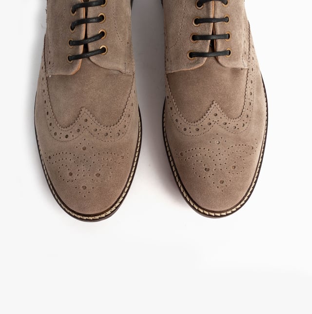 These beige brogue shoes feature a suede upper, textile lining, rubber sole, and lace-up closure. Designed for comfort, they are suitable for formal occasions and low-top style