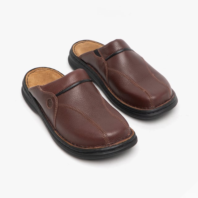 Esta mule de cuero para hombres cuenta con un forro textil transpirable, suela de poliuretano y un diseño sin cierre con punta redonda, ofreciendo comodidad y un tacón plano para un uso casual.