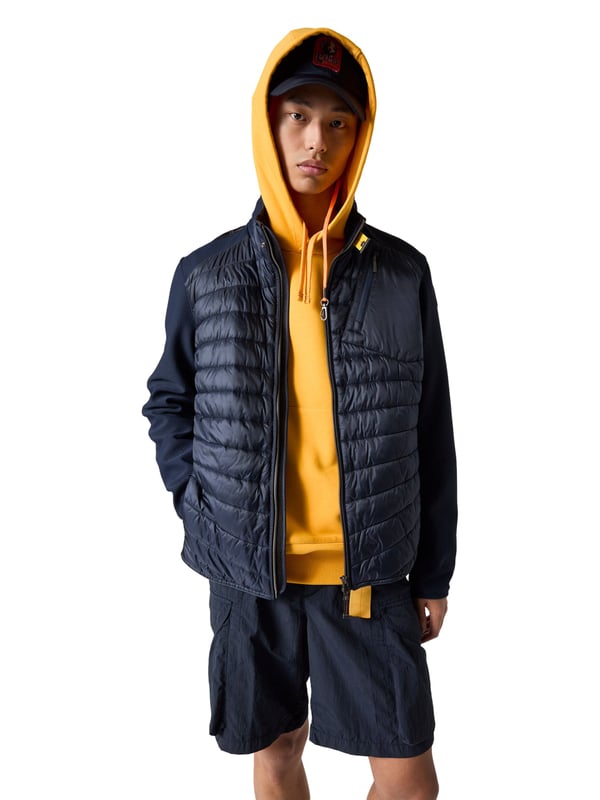 Een sportieve look ontmoet slimme functie - dit jack combineert beide in stijl. De slim fit creëert een modern, nauwsluitend silhouet. De mix van materialen creëert een spannend contrast tussen structuur en comfort. De opstaande kraag met iconisch geel parachutehaaklint voegt een opvallend detail toe. Met de praktische ritszakken op de borst en rug zijn essentiële spullen altijd binnen handbereik. De zijzakken nodigen uit om je handen vrij te houden. Een tweewegritssluiting zorgt voor flexibiliteit, zowel op de fiets als tijdens een wandeling. Een labelpatch en subtiele logodetails ronden het authentieke ontwerp af. Het hoogwaardige materiaal voelt aangenaam licht aan - zelfs op koelere dagen. Dit jack is de ideale metgezel voor mannen met stijl en raffinement!