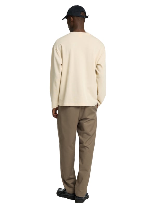 Dieses Herren-Longsleeve überzeugt mit einer lockeren Passform und einem modernen Look. Das weiche Feinstrickgewebe bietet dir hohen Tragekomfort und ein angenehmes Hautgefühl – ideal für jeden Tag. Der klassische Rundhalsausschnitt sorgt für eine zeitlose Optik. Überschnittene Schultern unterstreichen den entspannten Stil und bieten optimale Bewegungsfreiheit. Dank seines luftigen Schnitts eignet sich das Longsleeve perfekt für den angesagten Layering-Style. Das gewebte Label innen bleibt dezent und hochwertig. Vielseitig kombinierbar – ob unter einer Jacke, einem Hemd oder solo getragen. Ein Must-have für moderne Casual-Outfits. Die hochwertige Verarbeitung sorgt für langlebige Qualität. Dein stilvoller Begleiter für entspannte Looks.