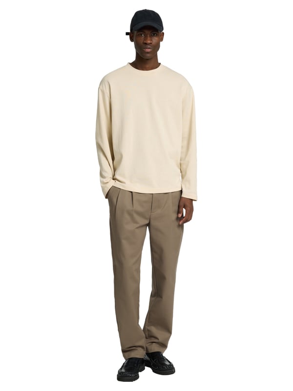 Dieses Herren-Longsleeve überzeugt mit einer lockeren Passform und einem modernen Look. Das weiche Feinstrickgewebe bietet dir hohen Tragekomfort und ein angenehmes Hautgefühl – ideal für jeden Tag. Der klassische Rundhalsausschnitt sorgt für eine zeitlose Optik. Überschnittene Schultern unterstreichen den entspannten Stil und bieten optimale Bewegungsfreiheit. Dank seines luftigen Schnitts eignet sich das Longsleeve perfekt für den angesagten Layering-Style. Das gewebte Label innen bleibt dezent und hochwertig. Vielseitig kombinierbar – ob unter einer Jacke, einem Hemd oder solo getragen. Ein Must-have für moderne Casual-Outfits. Die hochwertige Verarbeitung sorgt für langlebige Qualität. Dein stilvoller Begleiter für entspannte Looks.
