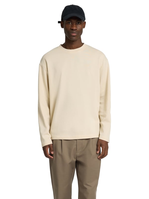 Dieses Herren-Longsleeve überzeugt mit einer lockeren Passform und einem modernen Look. Das weiche Feinstrickgewebe bietet dir hohen Tragekomfort und ein angenehmes Hautgefühl – ideal für jeden Tag. Der klassische Rundhalsausschnitt sorgt für eine zeitlose Optik. Überschnittene Schultern unterstreichen den entspannten Stil und bieten optimale Bewegungsfreiheit. Dank seines luftigen Schnitts eignet sich das Longsleeve perfekt für den angesagten Layering-Style. Das gewebte Label innen bleibt dezent und hochwertig. Vielseitig kombinierbar – ob unter einer Jacke, einem Hemd oder solo getragen. Ein Must-have für moderne Casual-Outfits. Die hochwertige Verarbeitung sorgt für langlebige Qualität. Dein stilvoller Begleiter für entspannte Looks.