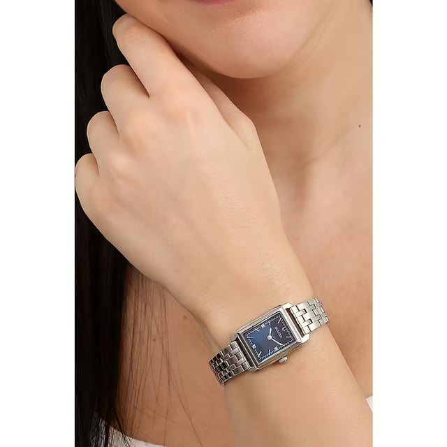 This Bulova Sutton Analogue Watch for Women is the perfect timepiece to wear or to gift. It's Silver  Rectangular case combined with the comfortable Silver Stainless steel watch band will ensure you enjoy this stunning timepiece without any compromise. Operated by a high quality Quartz movement and water resistant to 3 bars, your watch will keep ticking. This Bulova ladies’ timepiece adds further character to the already impressive Sutton Collection. High quality Silver Stainless steel strap, measuring 19 cm in length and 13 mm in width, with a Deployment clasp. Case measurement: 21 X 25 mm,case thickness: 7 mm, case colour: Silver and dial colour: Blue