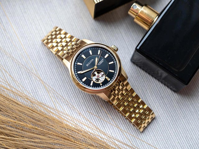 This Bulova Open Heart Analogue Watch for Men is the perfect timepiece to wear or to gift. It's Gold 40 mm Round case combined with the comfortable Gold Stainless steel watch band will ensure you enjoy this stunning timepiece without any compromise. Operated by a high quality Automatic movement and water resistant to 3 bars, your watch will keep ticking. This watch has an automatic watch movement ( recharged by any movement with your wrist; never needs a battery)  This Analogue watch is equipped with a Luminous Hands High quality Gold Stainless steel strap, measuring 21 cm in length and 19 mm in width, with a Fold over with push button clasp. Case diameter: 40 mm,case thickness: 11 mm, case colour: Gold and dial colour: Black