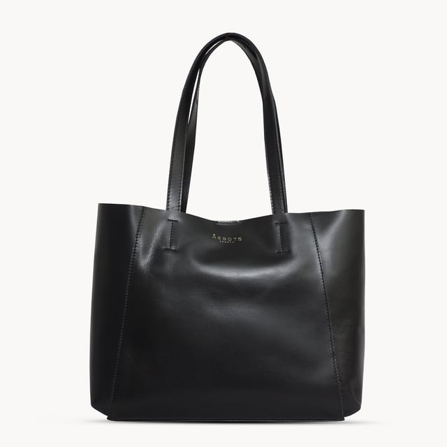 The 'Adela' genuine leather tote bag is beautifully handcrafted from premium Italian finish semi-soft and supple leather. Chosen for its durability, this timeless piece adds a touch of sophistication to all your outfits. Ideal for travel, meetings and everyday use, this chic handbag is a must-have addition to your collection of designer bags. Unlined for a robust and hard-wearing central compartment with an exposed, soft to the touch natural leather interior. Magnetic fastening closure opens to a roomy and spacious interior. Reinforced handle stitching to avoid snapping due to the load in the bag. Soft leather shoulder handles for a comfortable carry. Adorned with the inimitable Assots London clean finish gold embossed logo. Fittings colour: Shiny Gold. Composition: Body: 100% Genuine Leather. Lining: Unlined. DISCLAIMER : All pictures shown are for illustration purpose only. Actual product colour may vary due to different ambience lighting or the screen display settings.