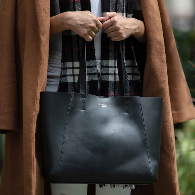 The 'Adela' genuine leather tote bag is beautifully handcrafted from premium Italian finish semi-soft and supple leather. Chosen for its durability, this timeless piece adds a touch of sophistication to all your outfits. Ideal for travel, meetings and everyday use, this chic handbag is a must-have addition to your collection of designer bags. Unlined for a robust and hard-wearing central compartment with an exposed, soft to the touch natural leather interior. Magnetic fastening closure opens to a roomy and spacious interior. Reinforced handle stitching to avoid snapping due to the load in the bag. Soft leather shoulder handles for a comfortable carry. Adorned with the inimitable Assots London clean finish gold embossed logo. Fittings colour: Shiny Gold. Composition: Body: 100% Genuine Leather. Lining: Unlined. DISCLAIMER : All pictures shown are for illustration purpose only. Actual product colour may vary due to different ambience lighting or the screen display settings.