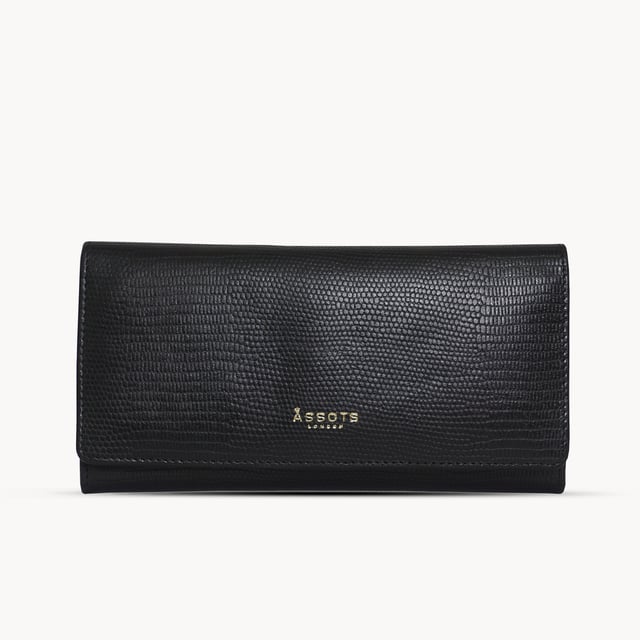 The ‘Claire’ flapover ladies purse is handcrafted with the premium lizard textured leather to give that designer look. Equipped with RFID technology, this practical ladies purse features a magnetic fastening closure with plenty of room to organise your cash, cards and coins. This large leather ladies purse is perfect to compliment your handbag and fits in easily. Stay safe and organised with ‘Claire’ the perfect addition to your collection of purses ideal for all outfits and occasions. Secured flap over magnetic fastening closure to store your essentials safely and securely. Foldover flap design. Equipped with RFID technology for safety. Additional back zip pocket to ensure you don’t run out of space. Two note compartments. Eight internal card compartments. Two windowed ID slots. Assots branded lined interiors. Lightweight for easy carry. Fittings Colour: Clean Brass. Composition: Body: 100% Genuine Leather. Lining: 100% Cotton. DISCLAIMER : All pictures shown are for illustration purpose only. Actual product colour may vary due to different ambience lighting or the screen display settings.