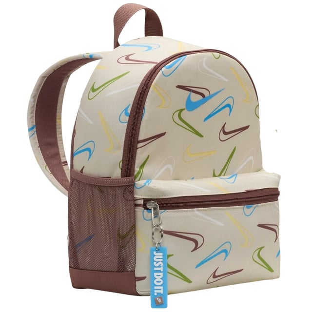 The Nike Youth All-Over Brand Logo Cream Bag combines style and practicality for young athletes and everyday use. Crafted from durable 100% polyester, this mini backpack features a cream base with a vibrant, multicoloured Nike Swoosh logo pattern that covers the entire bag, making it stand out. It offers a spacious 11-litre main compartment perfect for books, sports gear, or daily essentials, plus a secure front zip pocket for smaller items. Adjustable straps ensure a comfortable fit, while reliable zip fastenings keep belongings safe. Made in Vietnam, this backpack is a versatile and trendy choice for youth on the go