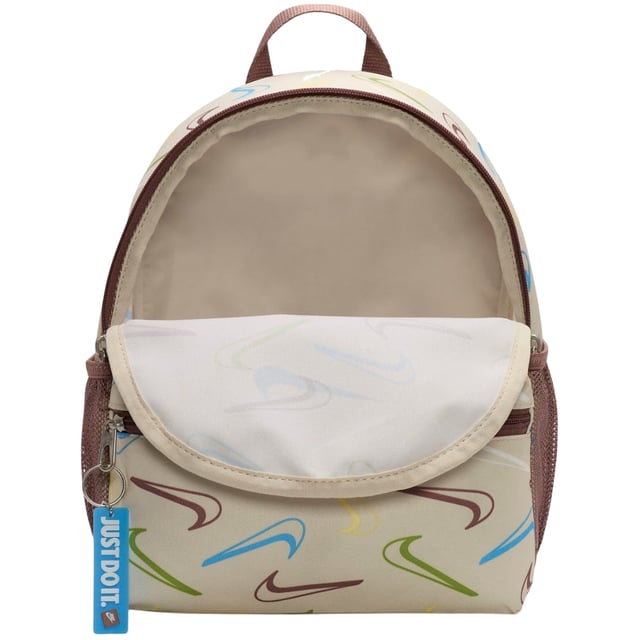 The Nike Youth All-Over Brand Logo Cream Bag combines style and practicality for young athletes and everyday use. Crafted from durable 100% polyester, this mini backpack features a cream base with a vibrant, multicoloured Nike Swoosh logo pattern that covers the entire bag, making it stand out. It offers a spacious 11-litre main compartment perfect for books, sports gear, or daily essentials, plus a secure front zip pocket for smaller items. Adjustable straps ensure a comfortable fit, while reliable zip fastenings keep belongings safe. Made in Vietnam, this backpack is a versatile and trendy choice for youth on the go