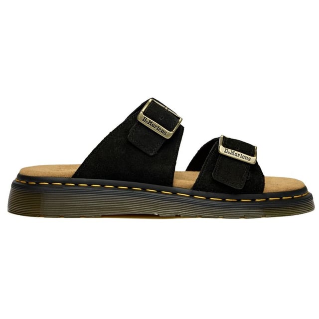 The Dr Martens Josef brings the brand's rebellious DNA to warm-weather footwear with bold confidence. Crafted from rich black suede, these slides feature the iconic twin buckle design that's both functional and unmistakably DM. The signature AirWair sole delivers the comfort and durability you expect, while side-stitched construction ensures these sandals can handle whatever your summer throws at them.