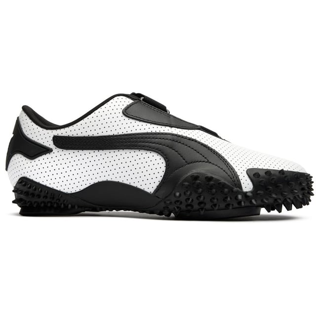 Der Puma Mostro in elegantem Weiß und Schwarz interpretiert Freizeit footwear neu mit seinem hybriden, skulpturalen Design. Diese markanten Lederschuhe verfügen über eine avantgardistische Gummisohle mit charakteristischen Spike-Details, die Aufmerksamkeit erregen und dabei überraschend praktisch sind. Die flache Silhouette bietet einen zeitgenössischen urbanen Stil mit unverkennbarem Puma-Erbe. Perfekt für modebewusste Personen, die innovatives Schuhdesign schätzen, ohne auf Komfort oder Alltagsbenutzbarkeit verzichten zu müssen.