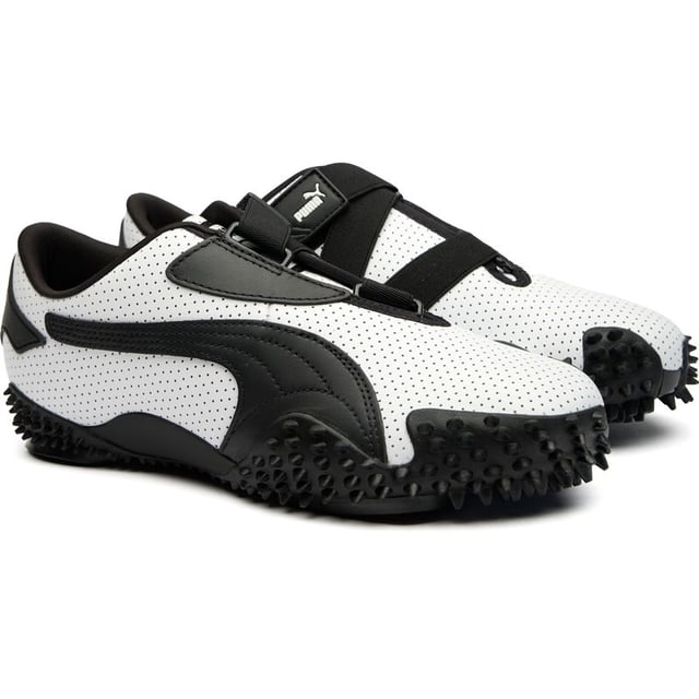Der Puma Mostro in elegantem Weiß und Schwarz interpretiert Freizeit footwear neu mit seinem hybriden, skulpturalen Design. Diese markanten Lederschuhe verfügen über eine avantgardistische Gummisohle mit charakteristischen Spike-Details, die Aufmerksamkeit erregen und dabei überraschend praktisch sind. Die flache Silhouette bietet einen zeitgenössischen urbanen Stil mit unverkennbarem Puma-Erbe. Perfekt für modebewusste Personen, die innovatives Schuhdesign schätzen, ohne auf Komfort oder Alltagsbenutzbarkeit verzichten zu müssen.