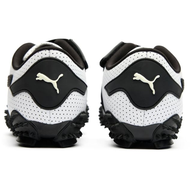 Der Puma Mostro in elegantem Weiß und Schwarz interpretiert Freizeit footwear neu mit seinem hybriden, skulpturalen Design. Diese markanten Lederschuhe verfügen über eine avantgardistische Gummisohle mit charakteristischen Spike-Details, die Aufmerksamkeit erregen und dabei überraschend praktisch sind. Die flache Silhouette bietet einen zeitgenössischen urbanen Stil mit unverkennbarem Puma-Erbe. Perfekt für modebewusste Personen, die innovatives Schuhdesign schätzen, ohne auf Komfort oder Alltagsbenutzbarkeit verzichten zu müssen.