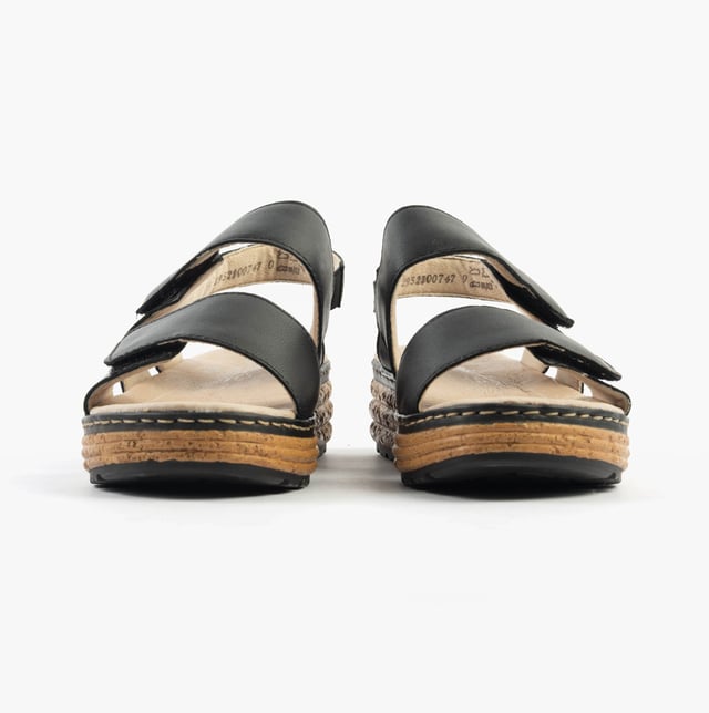 These open-toe women's sandals feature a leather upper, breathable lining, wedge heel, and extra-wide fit for comfort. Ideal for casual wear and easy to slip on with touch fasten closure
