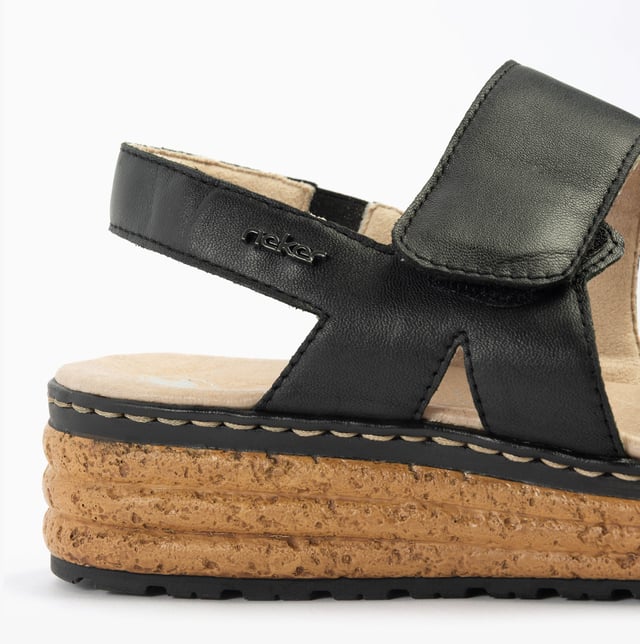 These open-toe women's sandals feature a leather upper, breathable lining, wedge heel, and extra-wide fit for comfort. Ideal for casual wear and easy to slip on with touch fasten closure