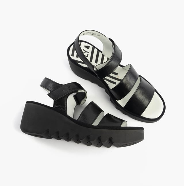 These open-toe wedge sandals feature a leather upper and lining with a rubber sole, offering comfort and breathability for casual wear