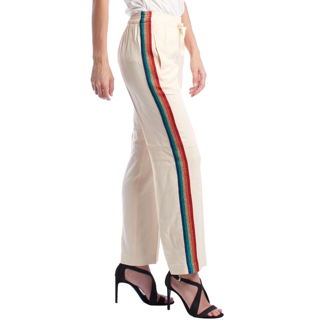 Pantalón fluido con banda lateral multicolor y cintura elástica.\n\nEste pantalón de estilo relajado combina comodidad y un diseño vibrante gracias a la banda lateral multicolor con acabado brillante. La cintura elástica con cordón ajustable proporciona un ajuste cómodo y favorecedor, ideal para looks casuales con un toque distintivo. Su corte recto estiliza la silueta sin renunciar al confort, y los bolsillos laterales aportan funcionalidad sin comprometer el diseño.\n\nDetalles:\n\nTipo de prenda: Pantalón largo fluido.\nMaterial: Tejido ligero con acabado satinado.\nEstilo: Deportivo chic.\nEstampado: Banda lateral con brillo multicolor.\nCintura: Elástica con cordón ajustable.\n\nUn pantalón mujer ideal para quienes buscan comodidad y estilo con un toque original. Perfecto para outfits urbanos con personalidad.\n Composición: 76% Acetato, 21% Viscosa, 3% Elastano\n Cuidados:\nLavar a mano en frío.\nNo usar lejía.\nNo secar en secadora.\nPlanchar a baja temperatura.
