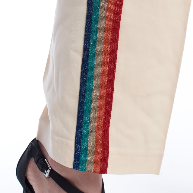 Pantalón fluido con banda lateral multicolor y cintura elástica.\n\nEste pantalón de estilo relajado combina comodidad y un diseño vibrante gracias a la banda lateral multicolor con acabado brillante. La cintura elástica con cordón ajustable proporciona un ajuste cómodo y favorecedor, ideal para looks casuales con un toque distintivo. Su corte recto estiliza la silueta sin renunciar al confort, y los bolsillos laterales aportan funcionalidad sin comprometer el diseño.\n\nDetalles:\n\nTipo de prenda: Pantalón largo fluido.\nMaterial: Tejido ligero con acabado satinado.\nEstilo: Deportivo chic.\nEstampado: Banda lateral con brillo multicolor.\nCintura: Elástica con cordón ajustable.\n\nUn pantalón mujer ideal para quienes buscan comodidad y estilo con un toque original. Perfecto para outfits urbanos con personalidad.\n Composición: 76% Acetato, 21% Viscosa, 3% Elastano\n Cuidados:\nLavar a mano en frío.\nNo usar lejía.\nNo secar en secadora.\nPlanchar a baja temperatura.