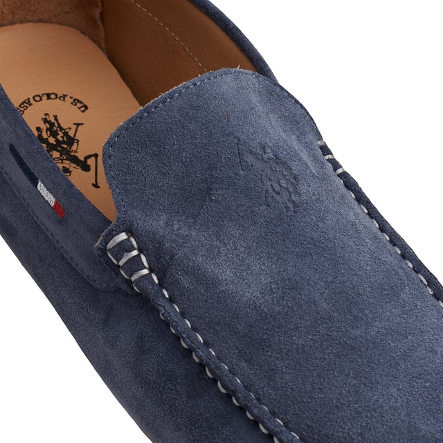 Suede loafers with a timeless design and maximum comfort.\n\n These US Polo Assn. loafers combine casual elegance and versatility to accompany you throughout your everyday life. Crafted from genuine suede, they stand out for their relaxed and refined style, ideal for an effortlessly polished look.\n\n Details:\n - Genuine suede upper.\n - Slip-on loafer design.\n - Lined interior.\n - Visible seams and meticulous finishes.\n - Flexible rubber sole with grooves.\n\n A shoe designed for those who value classic sophistication with timeless comfort. Men's loafers are perfect for pairing with chinos, Bermuda shorts, or jeans for any casual occasion.\n Composition: Exterior: Suede; Interior: Faux Leather; Sole: Synthetic\n Care:\nBrush with a suede brush to keep clean.\n Apply protective spray before use.\n Avoid water and air dry if it gets wet.\n Do not use soap or liquid products.