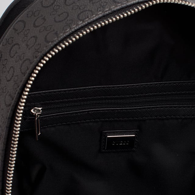 This Guess backpack features a contemporary design with an all-over Guess monogram print, ideal for those seeking a modern look with a visual identity. Its compact and functional silhouette makes it a practical everyday option, while still maintaining Guess's signature urban style.

 - Accessory type: Backpack.
 - Material: Synthetic leather-like material.
 - Texture: Monogram print with grained finish.
 - Hardware: Silver-tone metal.
 - Exterior details: Metallic Guess logo and front zipper pocket.
 - Interior details: Main compartment with zipper closure, interior organizing pockets.
 - Top handle for carrying by hand.
 - Adjustable rear straps.

 Guess reinterprets the classic backpack with a design that stands out for its personality. A perfect piece to accompany you to work, school, or on your urban adventures with a distinctive and functional touch.
 Measures: 25 x 32 x 12 cm
 Composition: 100% Polyurethane
 Care:
Clean with a soft, slightly damp cloth.
 Do not use abrasive products or detergents.
 Avoid prolonged exposure to the sun or extreme humidity.