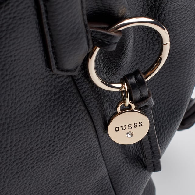 The Guess satchel combines sophistication and functionality in a timelessly elegant silhouette. Its structured design with top handles and an adjustable strap makes it a versatile everyday option. The metallic logo charm and thoughtful details complete a piece that adds distinction to any look.\n\n - Accessory type: Satchel bag.\n - Material: Synthetic leather-like material.\n - Texture: Granular.\n - Hardware: Silver-tone metal.\n - Exterior details: Front metal logo and decorative pendant with Guess charm.\n - Interior details: Main compartment with zipper closure and organizing pockets.\n - Rigid top handles.\n - Adjustable and removable strap for shoulder or cross-body carrying.\n\n Guess focuses on designs that stand out for their balance of style and utility. This satchel is the perfect option for those looking for a refined, spacious, and comfortable piece to elegantly accompany their days.\n Measures: 34 x 21 x 11 cm\n Composition: 100% Polyurethane\n Care:\nClean with a soft, slightly damp cloth.\n Do not use abrasive products or detergents.\n Avoid prolonged exposure to the sun or extreme humidity.