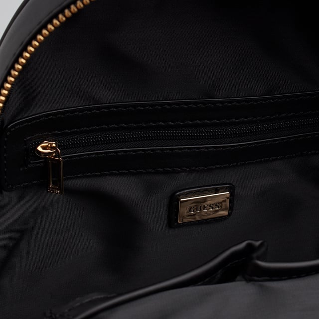 Esta mochila de Guess se presenta como una opción funcional y con estilo para el día a día. Su diseño moderno y compacto incluye un logotipo frontal en gran formato y un accesorio desmontable a juego. Con múltiples compartimentos y acabados metálicos, esta mochila combina moda y practicidad con el inconfundible sello de la marca.\n\nDetalles:\n- Tipo de accesorio: Mochila.\n- Material: Material sintético tipo piel.\n- Textura: Lisa.\n- Herraje: Metálico en tono dorado.\n- Detalles exteriores: Logo Guess en relieve y monedero desmontable con cremallera.\n- Detalles interiores: Compartimento principal con cierre de cremallera, 1 bolsillo con cremallera, 3 bolsillos abiertos.\n- Bolsillo frontal exterior con cremallera.\n- Asa superior para llevar en la mano.\n- Tirantes ajustables para un ajuste cómodo a la espalda.\n- Incluye bolsa guardapolvo.\n\nGuess reinventa la mochila clásica con una propuesta urbana, femenina y funcional. Ideal para quienes buscan comodidad sin renunciar a un look sofisticado, perfecta para el trabajo, los viajes o el uso diario con estilo.\n Medidas: Bolso: 23.5 x 28 x 9 cm; Monedero: 7 x 11 x 2 cm\n Composición: 100% Poliuretano\n Cuidados:\nLimpiar con un paño suave y ligeramente húmedo.\nNo usar productos abrasivos ni detergentes.\nEvitar la exposición prolongada al sol o humedad extrema.