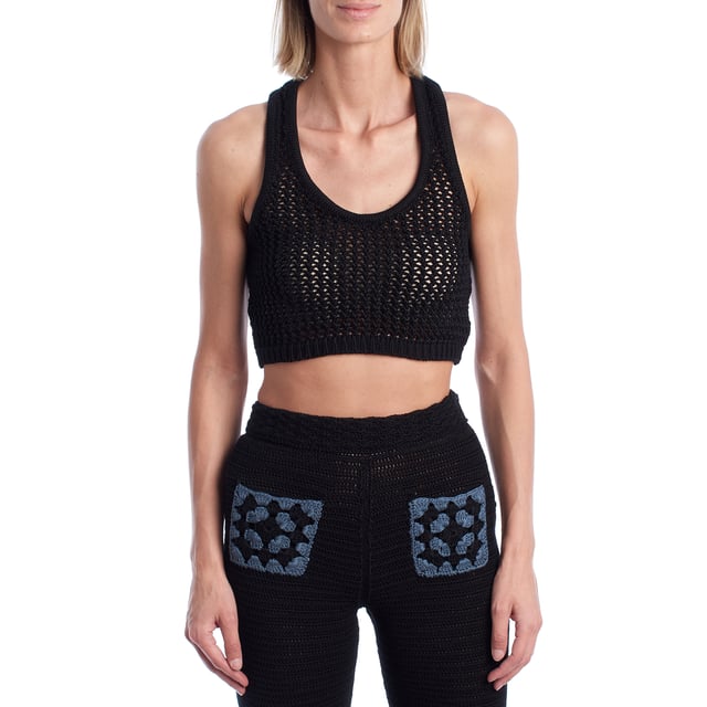 Este top corto confeccionado en punto calado combina estilo artesanal con una silueta deportiva. El diseño de escote redondo y espalda nadadora aporta un aire moderno y fresco, ideal para combinar con pantalones o faldas de punto para un conjunto coordinado. Su tejido abierto permite una mayor transpirabilidad y añade un efecto visual sugerente y veraniego.\n\nDetalles:\n- Corte: Cropped con ajuste ceñido.\n- Exterior: Tejido de punto calado artesanal.\n- Espalda: Diseño nadadora para un look deportivo.\n- Estilo: Casual y bohemio, ideal para verano.\n- Funcionalidad: Perfecto para llevar sobre bikini o como top de conjunto.\n\nCrea un conjunto llamativo combinándolo con su pantalón a juego, y eleva tus looks de verano con un toque boho-chic.\n Composición: 100% Algodón\n Cuidados:\nLavar a mano en agua fría. No usar secadora. Secar en plano.