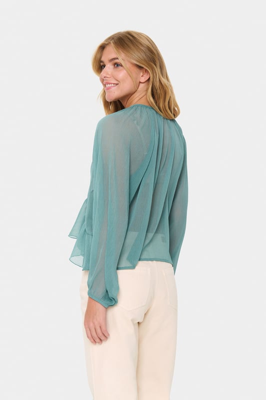 Die leichte Bluse mit Rüschen und lockerer Passform besticht durch einen Rundhalsausschnitt mit Bindeband, lange Ärmel und ein feminines Design. Ideal für flexible Stylingmöglichkeiten und angenehmen Tragekomfort.  Schonwäsche 30°, Nicht bleichen, Nicht im Trockner trocknen, Tropnass aufhängen, Kalt bügeln max. 110° C, Nicht trockenreinigen  100% Polyester (Recycelt)
