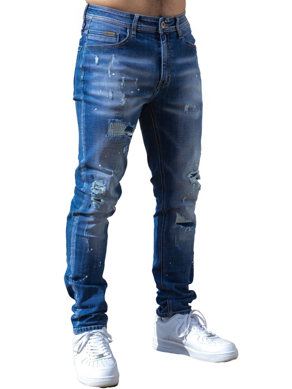 Enzo Milano | Mens Ripped Jeans Upgrade your denim game with the Enzo Milano slim fit Jeans for men, crafted for style and comfort. Featuring bold ripped and repaired detailing, these denim jeans deliver a rugged, contemporary look accentuated by unique paint splash accents. The tapered leg creates a modern silhouette, while premium stretch fabric ensures ease of movement and a perfect fit. A concealed zip fly fastening adds a clean finish, complemented by a classic 5-pocket design for everyday practicality. Finished with the signature Enzo Milano PU branded label at the back, these denim trousers embody high-quality craftsmanship and distinctive urban flair.