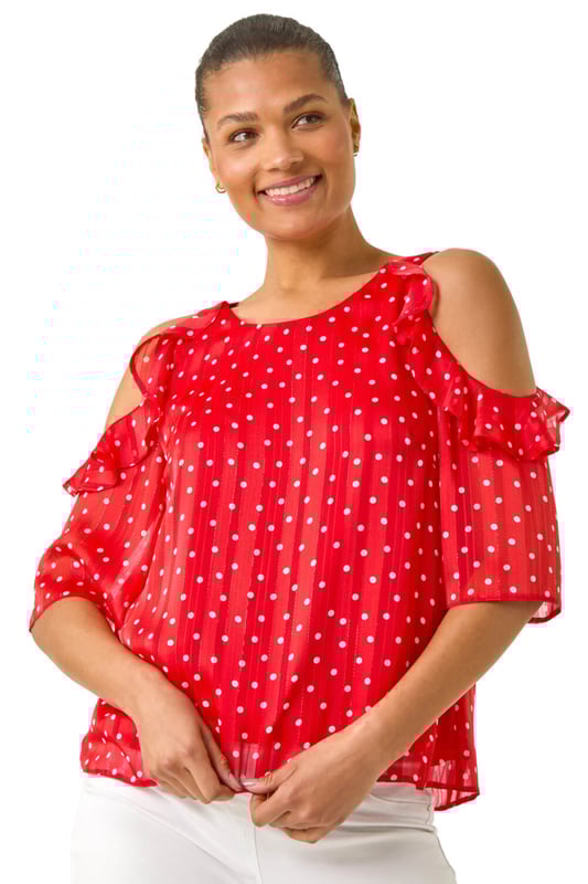 Spot Print Frill Cold Shoulder Top from Roman. Get ready to make a statement this Spring Summer with this spot print cold shoulder top. The trendy round neckline and frill shoulder detail add a fun and flirty touch to this piece, crafted from a comfortable satin woven fabric. Perfect for sunny days, pair this top with linen trousers and sandals for a sophisticated and stylish look!