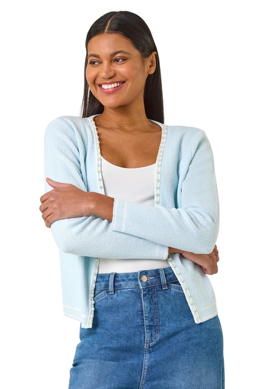 Faux Pearl Trim Cardigan from Roman. Add a touch of elegance to any outfit with this chic faux pearly detail cardigan. The perfect Spring/Summer cover-up, featuring long sleeves and an edge to edge front for effortless style. Layer over a floral dress and heels for a classic and sophisticated look.